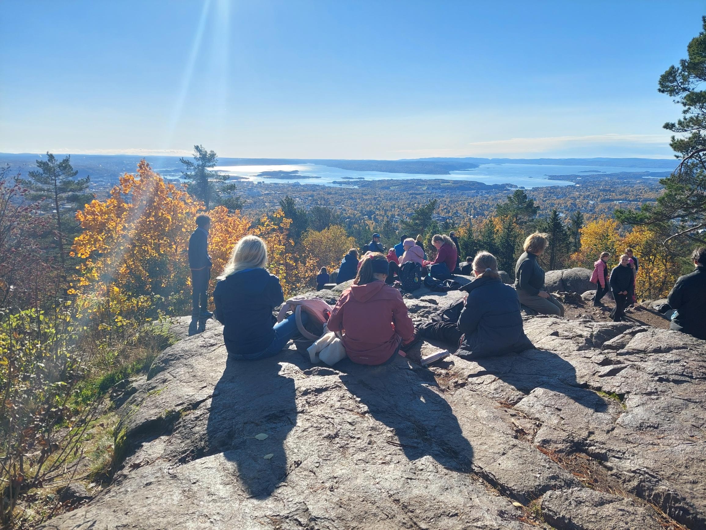 en gruppe mennesker som sitter på en høyde med utsikt over en by