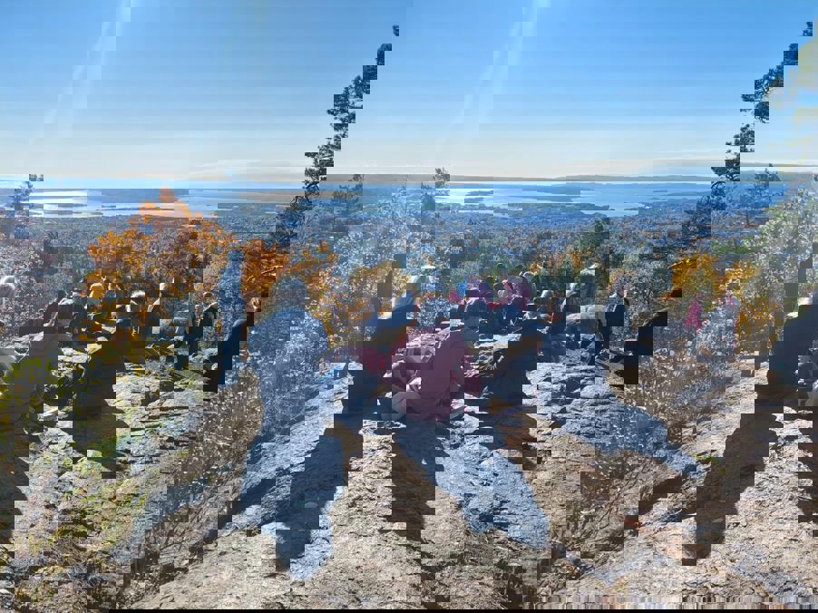 Foto: Heidi Berre en gruppe mennesker som sitter på en høyde med utsikt over en by