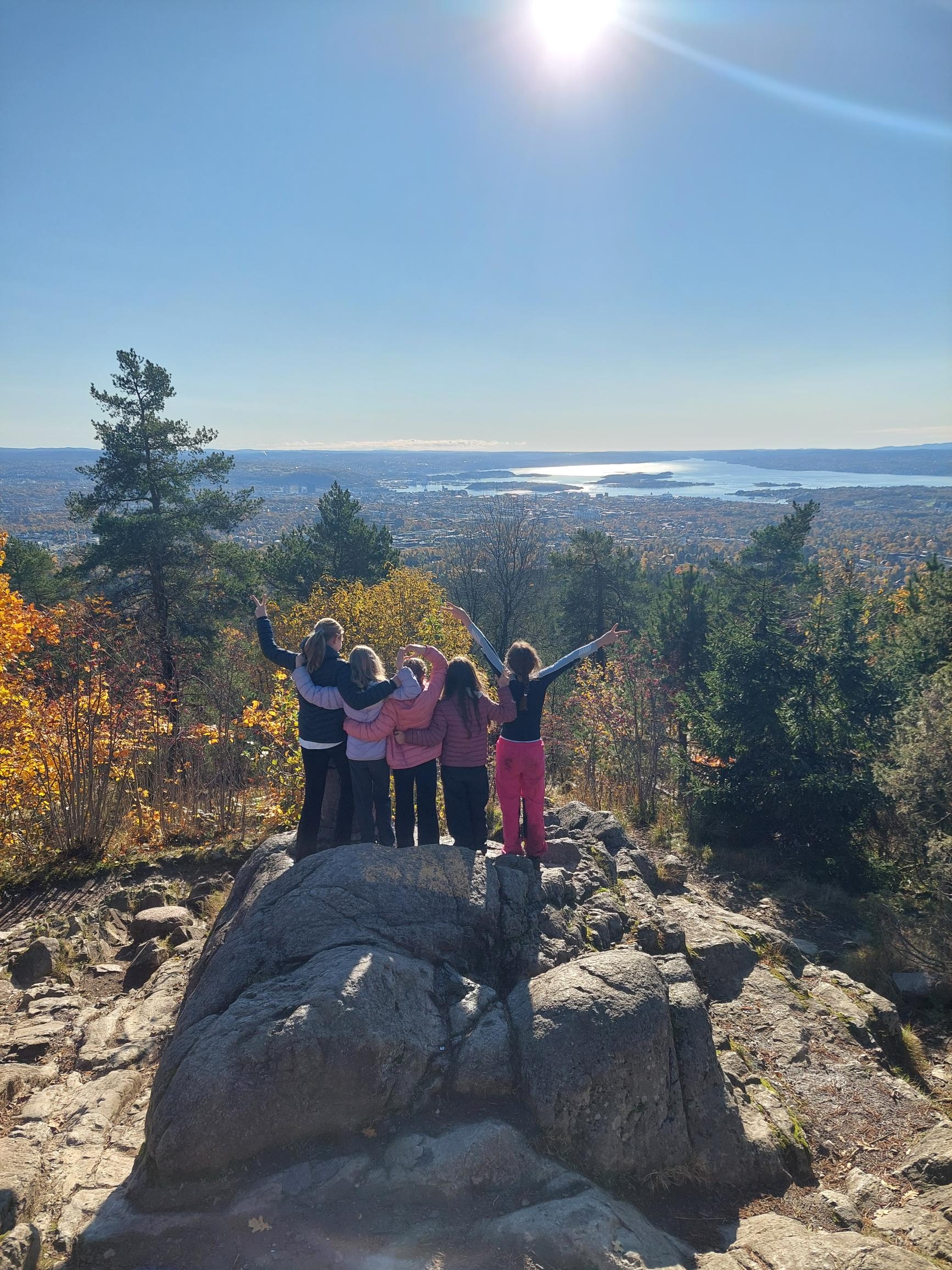en gruppe mennesker som står på en stein med utsikt over en dal