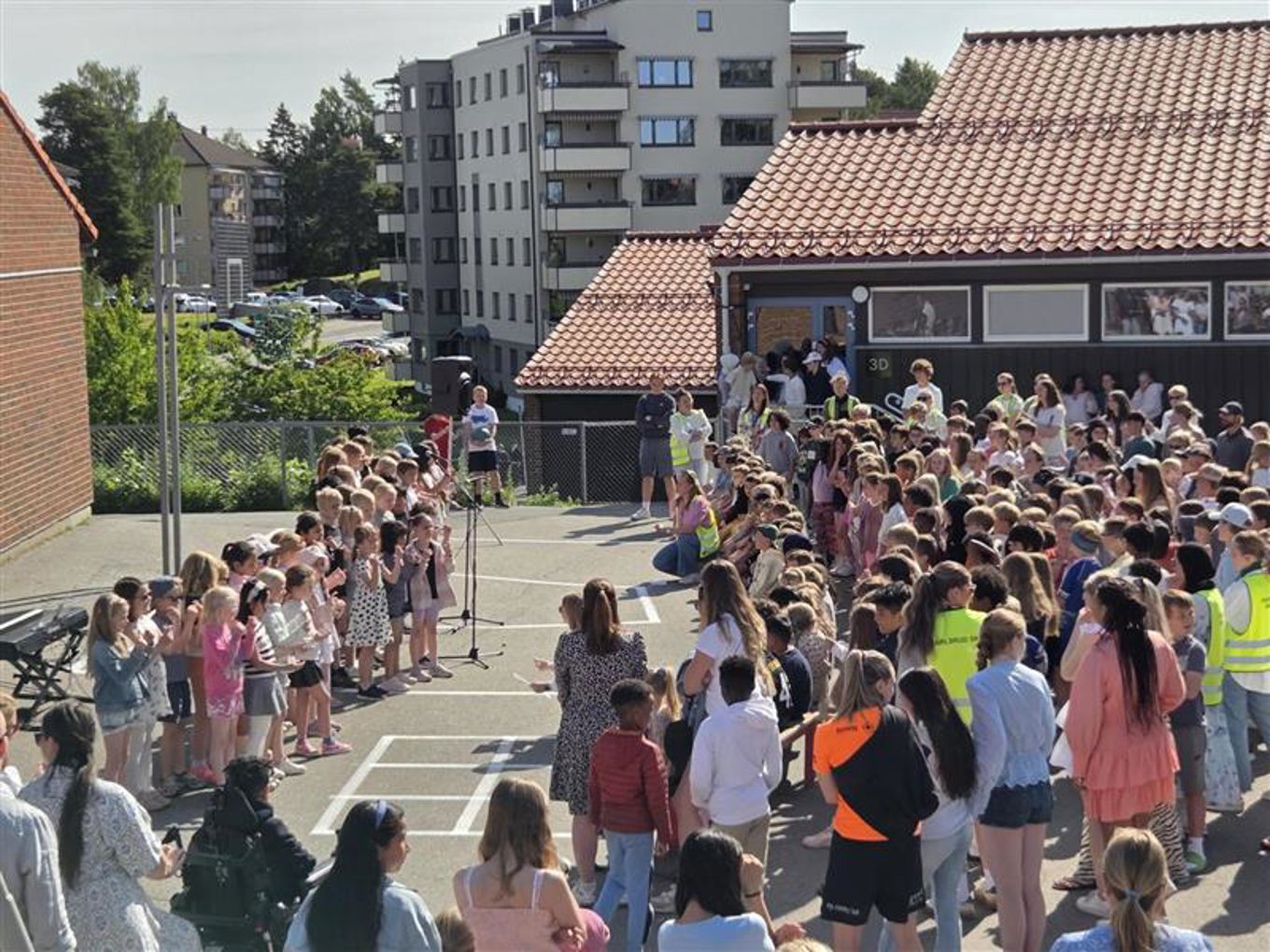 Elever som som står i skolegården og synger.