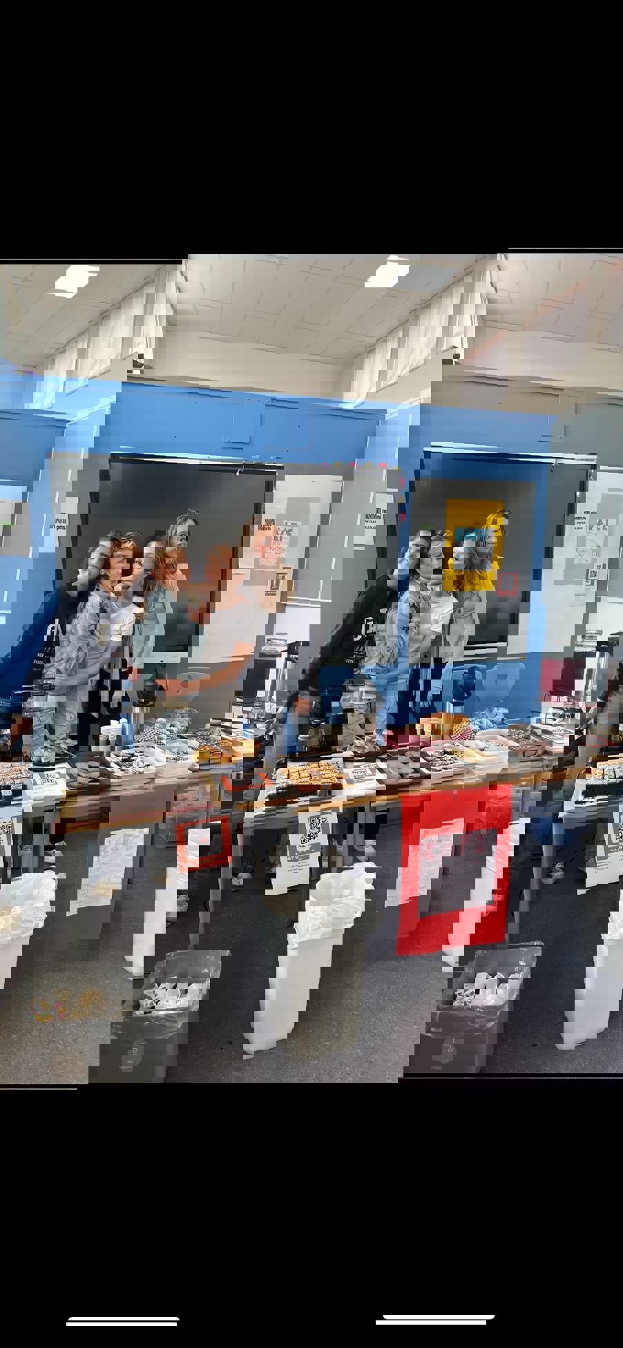 en gruppe mennesker som står foran et bord med mat på