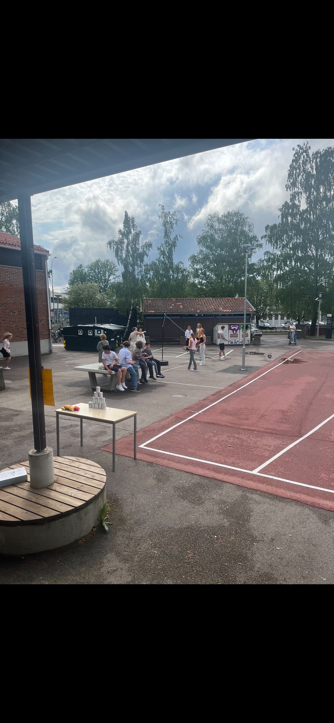 En gruppe mennesker som sitter på en benk foran et bål