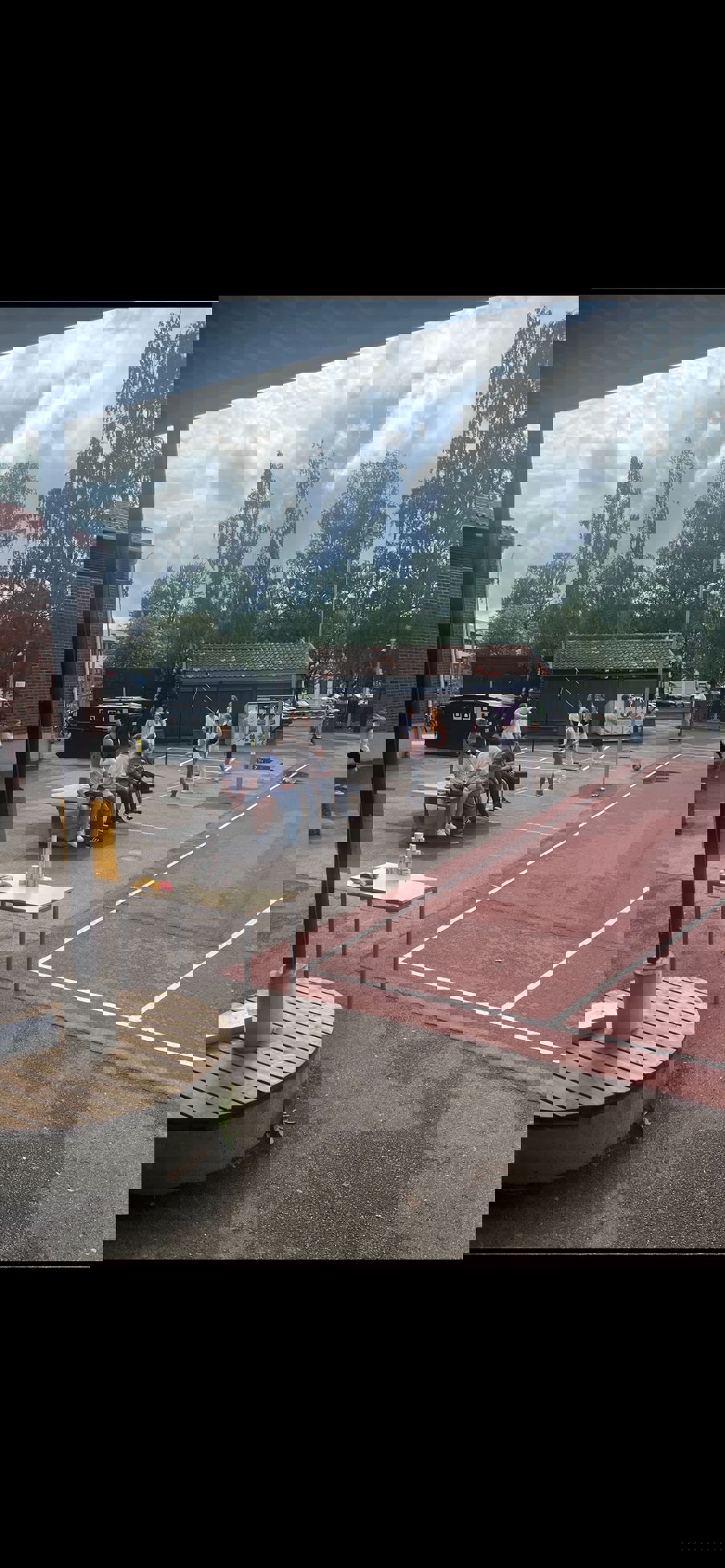 En gruppe mennesker som sitter på en benk foran et bål