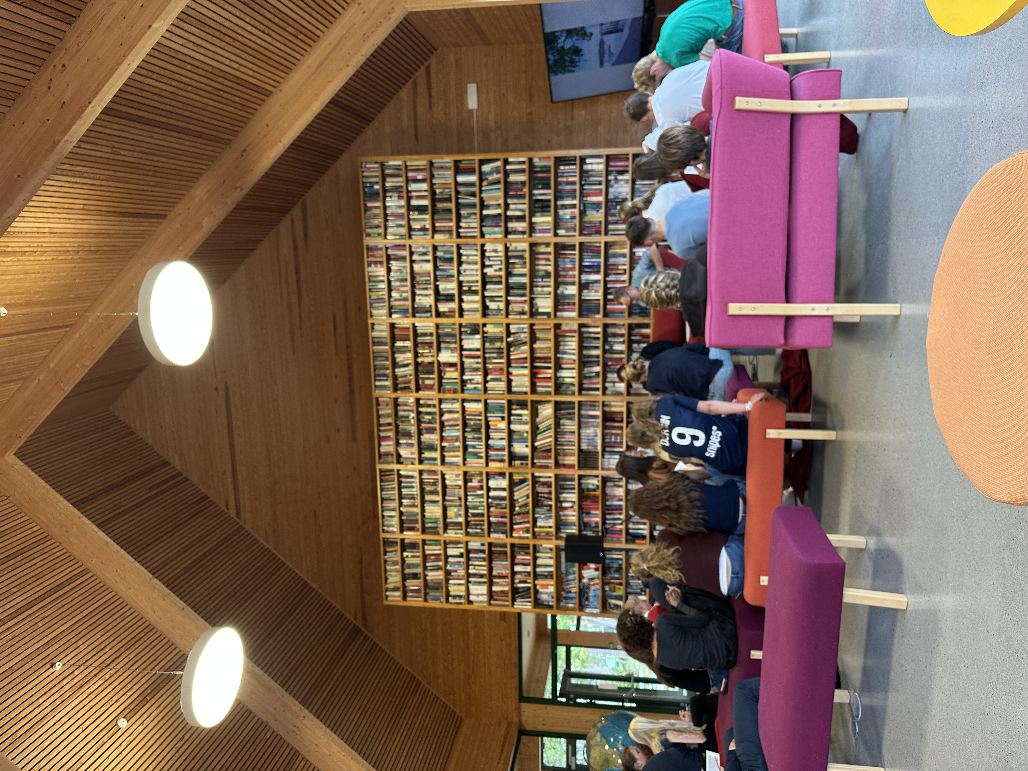 en gruppe mennesker som sitter i et bibliotek