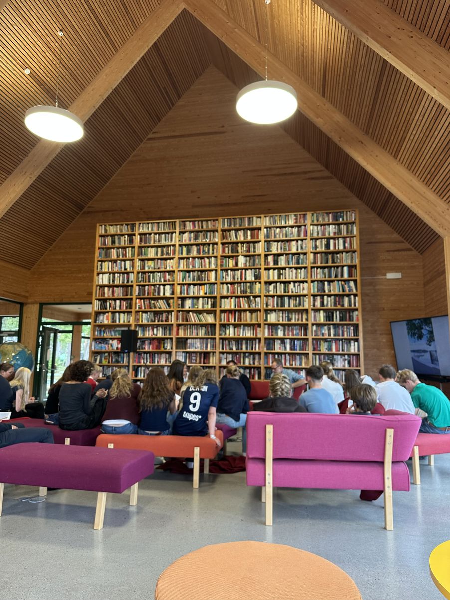 Foto: Hanne Mostervik Dalby en gruppe mennesker som sitter i et bibliotek