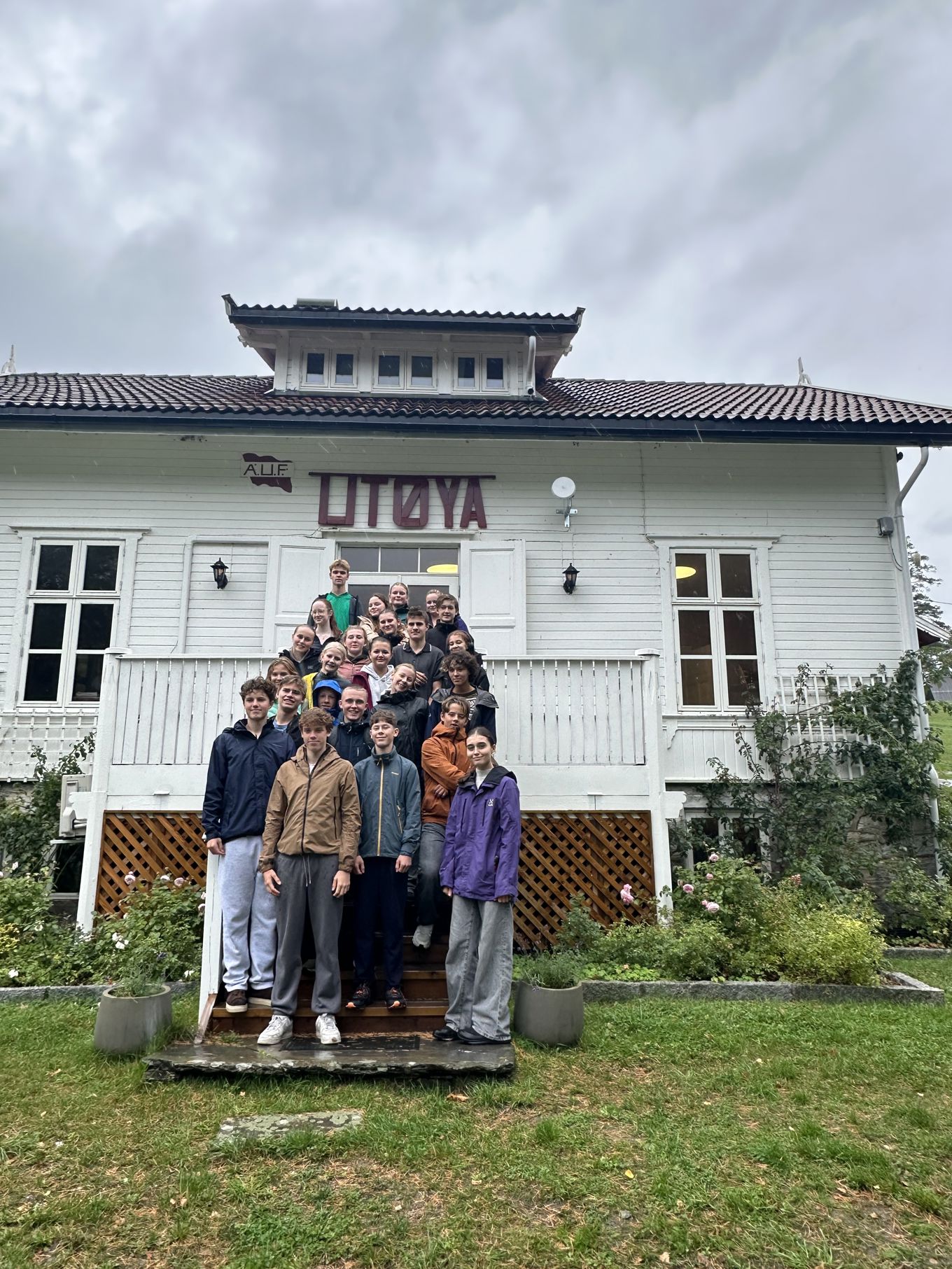 Foto: Hanne Mostervik Dalby en gruppe ungdom som står foran hovedhuset på Utøya